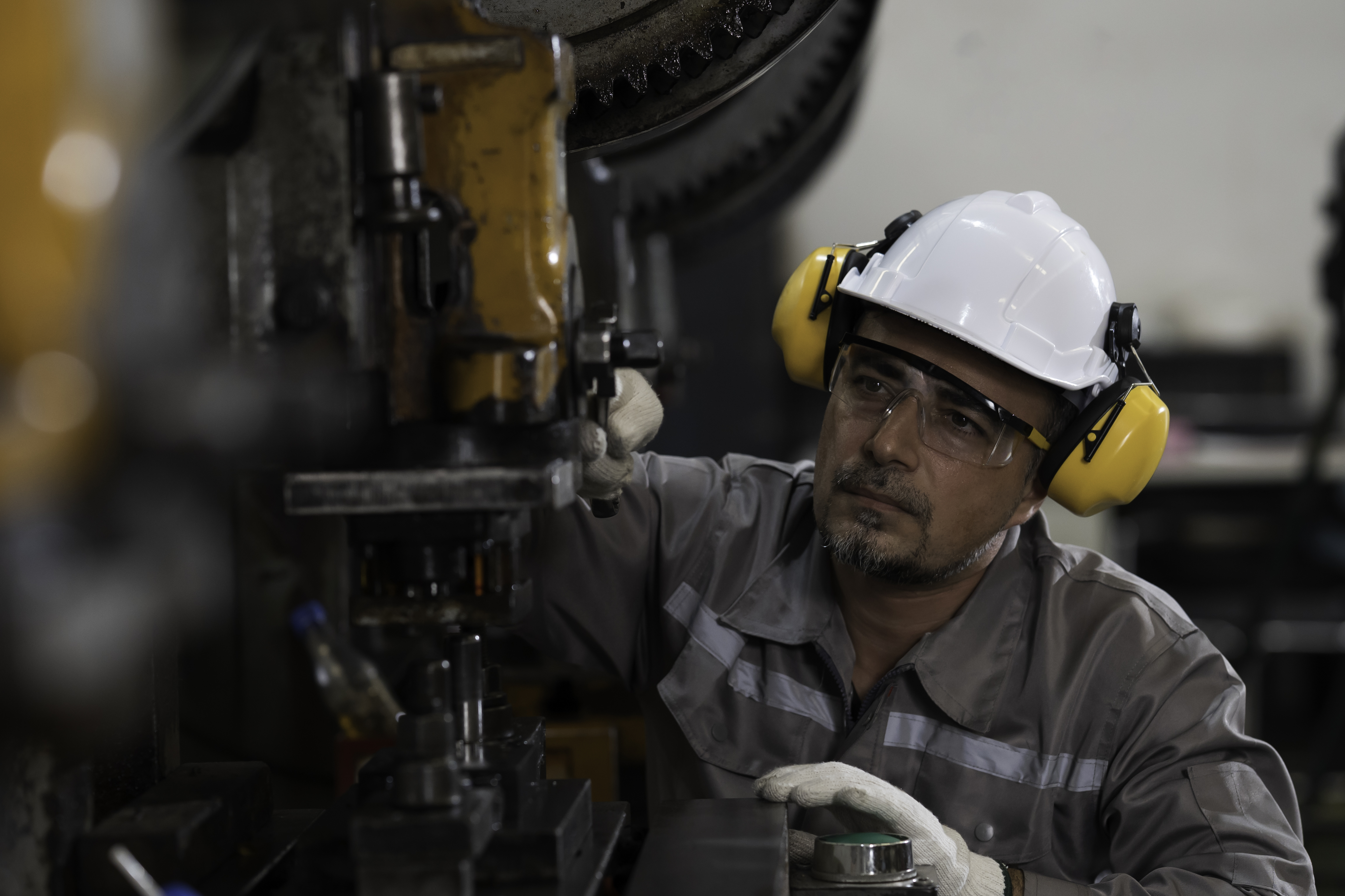 Male engineer maintenance production machine in industry factory. Male technician repair heavy industry machine in factory